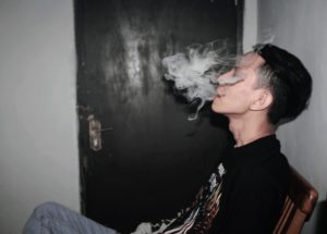 Sitting man exhaling smoke